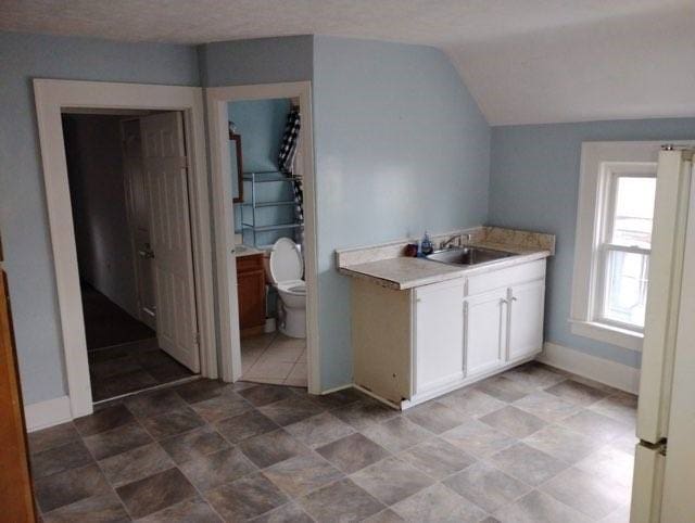 443 E 27 Th St, Erie, PA 16504 - kitchen with white cabinets, a sink, freestanding refrigerator, lofted ceiling, and light countertops