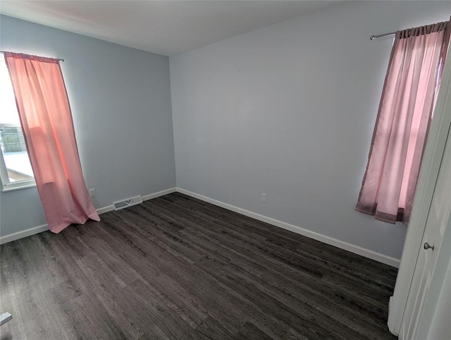 spare room featuring dark wood-type flooring