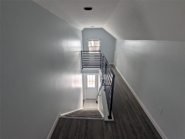 stairs featuring hardwood / wood-style flooring and lofted ceiling