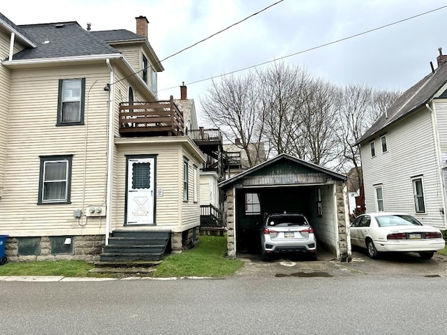 view of front of property featuring a balcony, an outbuilding, and a garage