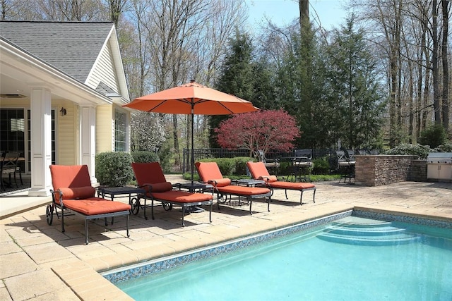 view of pool with a grill, area for grilling, and a patio