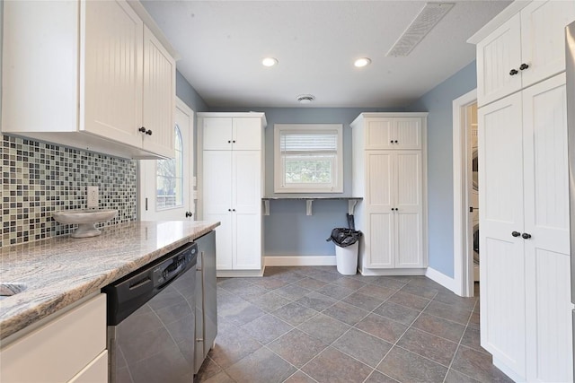 kitchen with white cabinetry, stainless steel dishwasher, tasteful backsplash, and light stone counters