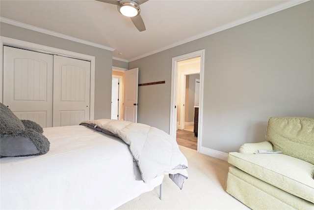 bedroom featuring ceiling fan, a closet, light colored carpet, and ornamental molding