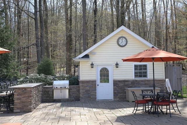 view of patio featuring an outdoor kitchen and a grill