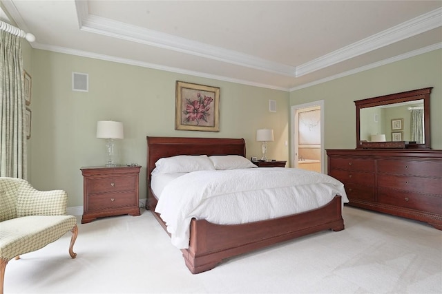 carpeted bedroom with a tray ceiling, ensuite bath, and crown molding