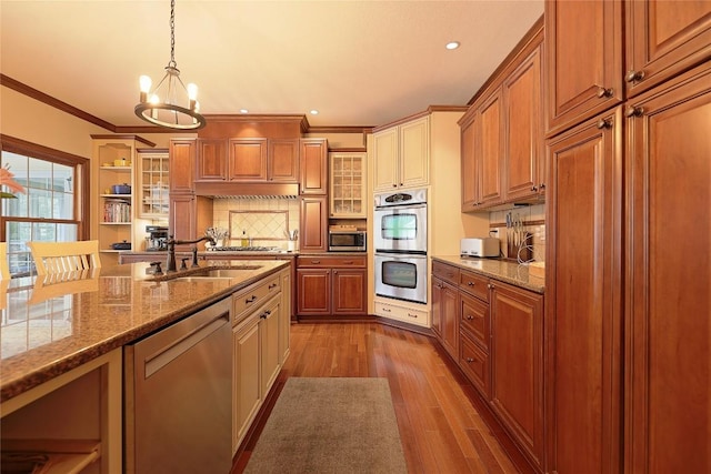 kitchen featuring sink, light hardwood / wood-style flooring, ornamental molding, decorative light fixtures, and stainless steel appliances