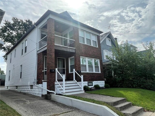 731 E 28th St, Erie, PA 16504 - view of front of property with brick siding, a front lawn, and a balcony