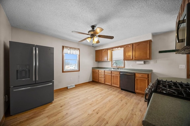 kitchen featuring ceiling fan, light hardwood / wood-style floors, a textured ceiling, black refrigerator with ice dispenser, and stainless steel dishwasher