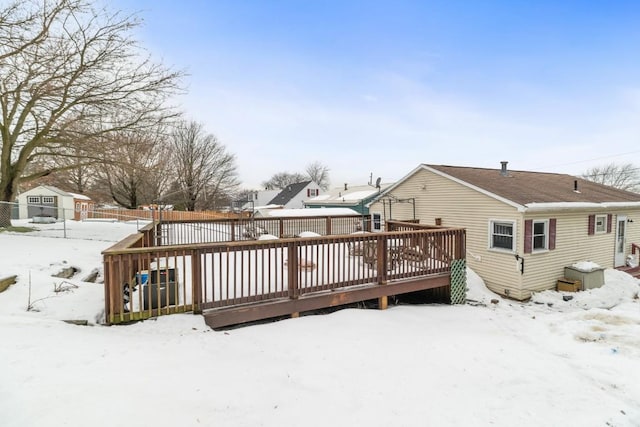 snow covered back of property with a deck