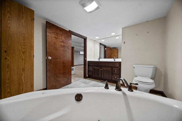 bathroom with vanity, a washtub, and toilet