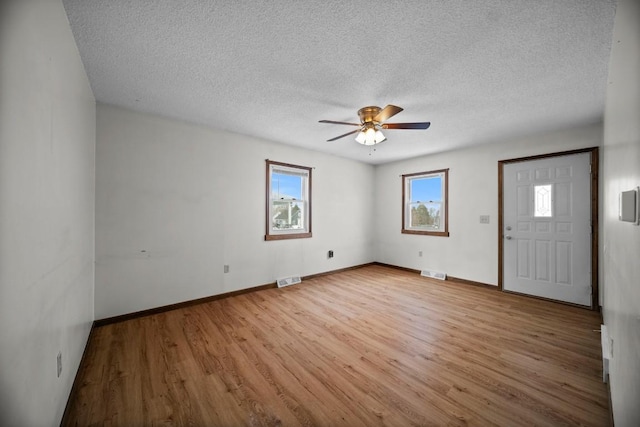 entryway with ceiling fan, a textured ceiling, and light hardwood / wood-style floors