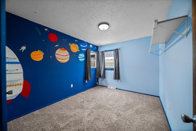 carpeted spare room featuring a textured ceiling