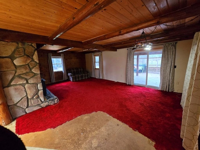 unfurnished living room featuring beam ceiling, a wealth of natural light, and wood ceiling