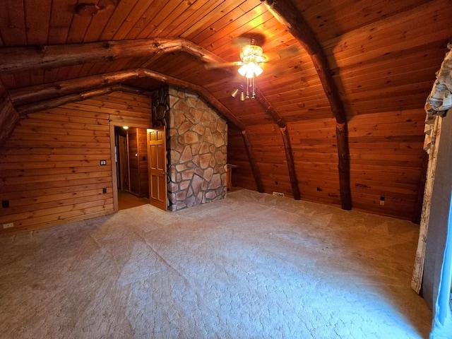 additional living space with carpet flooring, ceiling fan, lofted ceiling with beams, wood walls, and wood ceiling