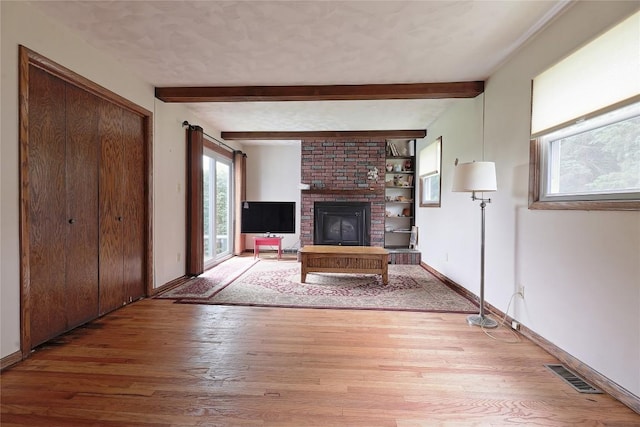 5219 W 52nd St, Fairview, PA 16415 - unfurnished living room with wood finished floors, beam ceiling, and a fireplace