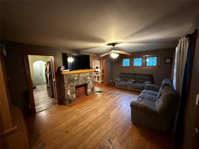 20743 Alden St, Meadville, PA 16335 - living area with wood finished floors, a ceiling fan, arched walkways, and a stone fireplace