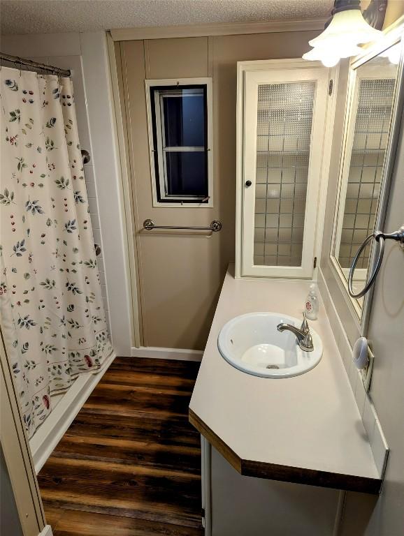 bathroom with vanity, hardwood / wood-style floors, a textured ceiling, and a shower with curtain