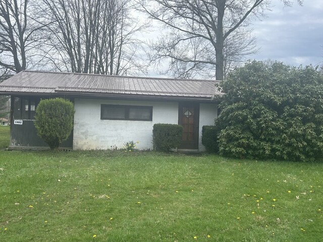 1402 Hickory St, Espyville, PA 16424 - view of side of property with concrete block siding, metal roof, and a lawn