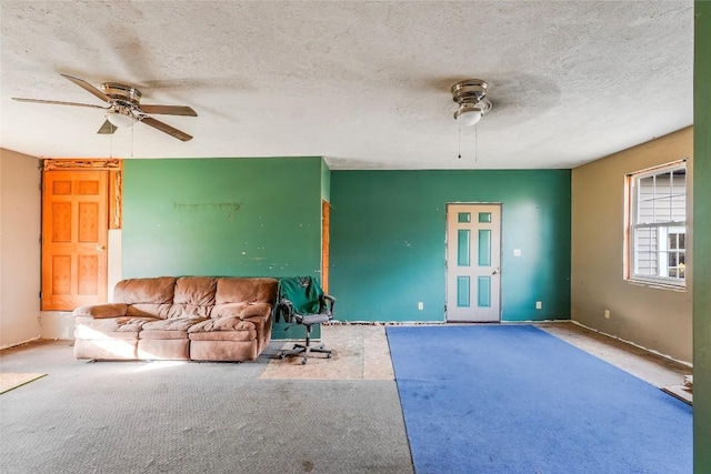 unfurnished living room featuring carpet flooring, ceiling fan, and a textured ceiling