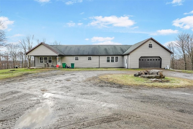 ranch-style home with covered porch and a garage