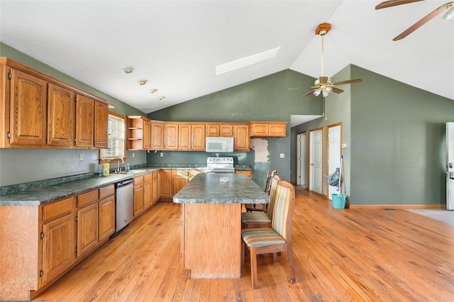 kitchen featuring white appliances, a kitchen bar, a center island, and light hardwood / wood-style flooring