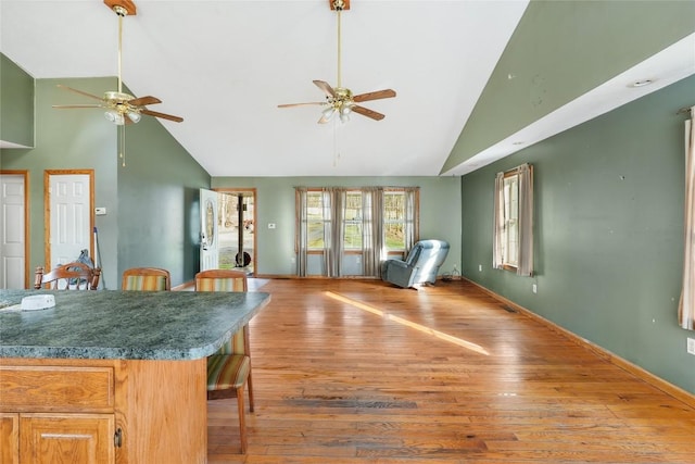 interior space with ceiling fan, high vaulted ceiling, and hardwood / wood-style flooring