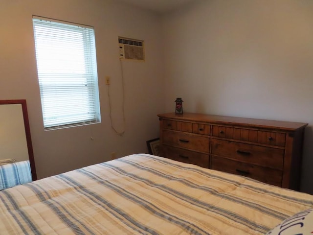 bedroom featuring multiple windows and a wall mounted AC