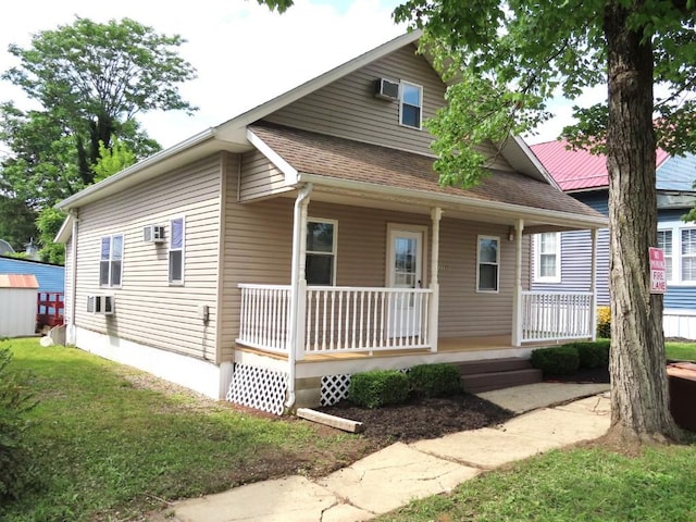 bungalow with covered porch and a front yard