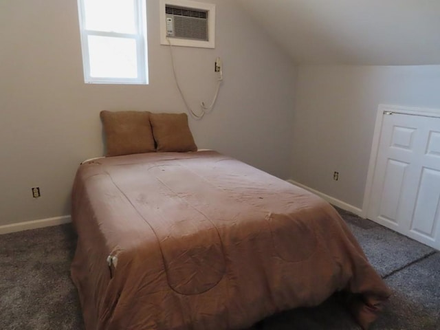 bedroom featuring dark colored carpet, a wall unit AC, and lofted ceiling