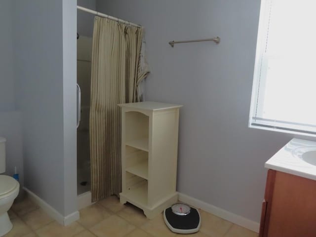 bathroom featuring tile patterned floors, toilet, vanity, and a shower with shower curtain