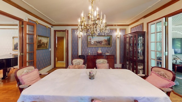 dining room with crown molding, a notable chandelier, and light wood-type flooring