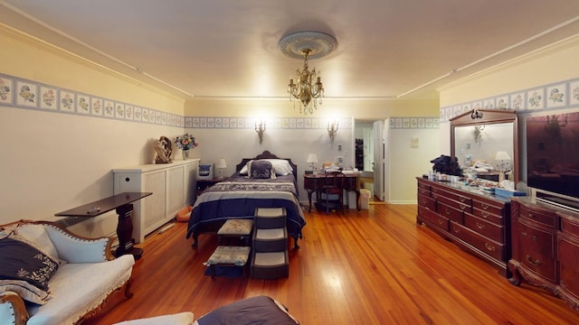 bedroom with crown molding, light hardwood / wood-style flooring, and an inviting chandelier