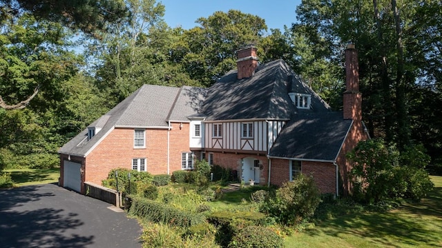 back of house featuring a yard and a garage