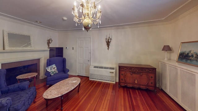 sitting room featuring radiator, hardwood / wood-style flooring, a chandelier, ornamental molding, and heating unit