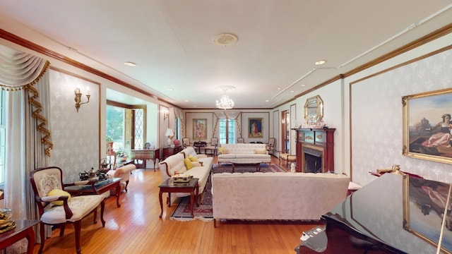 living room featuring a chandelier, light wood-type flooring, and ornamental molding