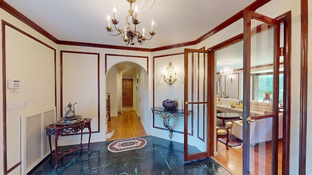 interior space with hardwood / wood-style floors, an inviting chandelier, and crown molding