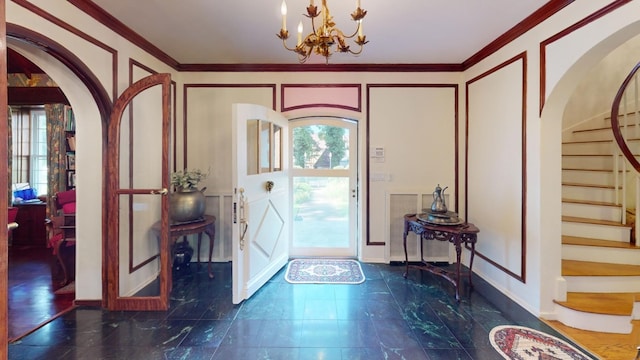 foyer with ornamental molding and a notable chandelier