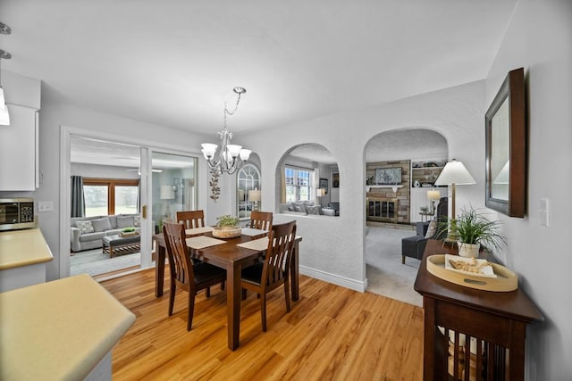 5124 W Ridge Rd, Erie, PA 16506 - dining room featuring arched walkways, light wood-style flooring, a chandelier, and plenty of natural light