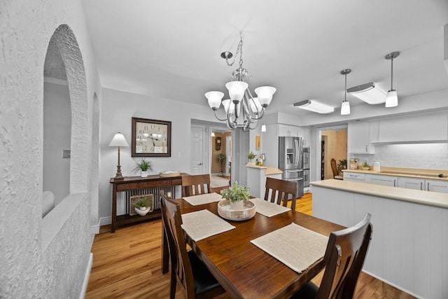 5124 W Ridge Rd, Erie, PA 16506 - dining space featuring a chandelier, light wood finished floors, and arched walkways