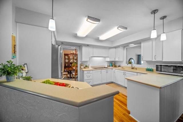 5124 W Ridge Rd, Erie, PA 16506 - kitchen featuring appliances with stainless steel finishes, light countertops, a peninsula, white cabinetry, and light wood-type flooring