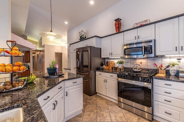 kitchen featuring decorative light fixtures, white cabinetry, tasteful backsplash, and appliances with stainless steel finishes