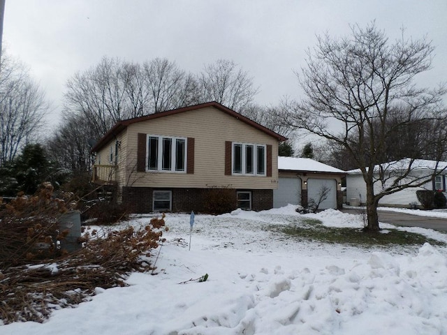 snow covered property with a garage