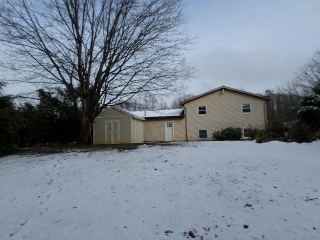 view of snow covered exterior with a storage shed