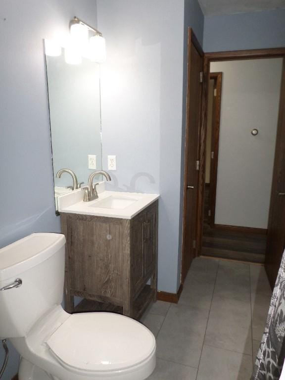 bathroom featuring tile patterned floors, vanity, and toilet