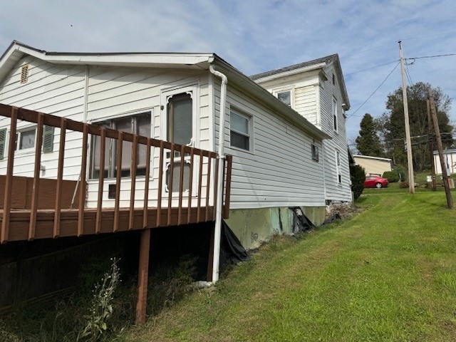 view of side of property featuring a wooden deck and a yard