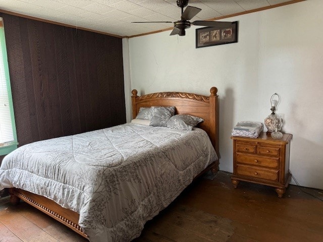 bedroom featuring ceiling fan, dark hardwood / wood-style floors, and ornamental molding