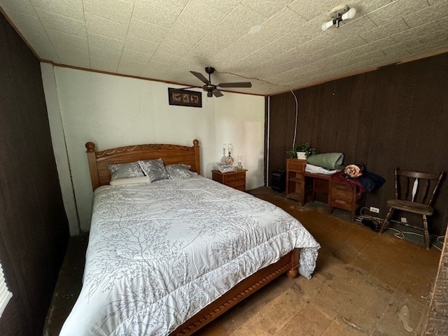 bedroom featuring ceiling fan and wood walls