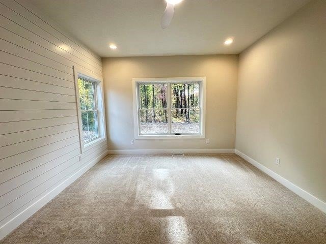 carpeted spare room featuring ceiling fan