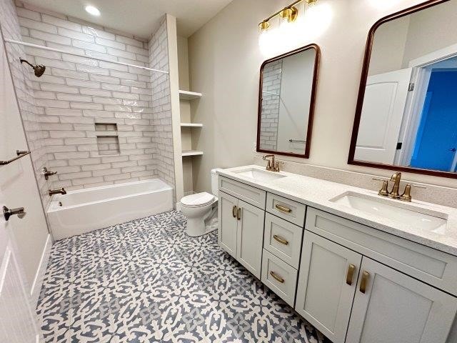 full bathroom featuring tiled shower / bath combo, toilet, and vanity