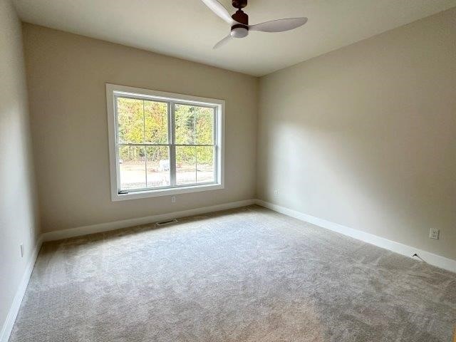 unfurnished room with ceiling fan and light colored carpet